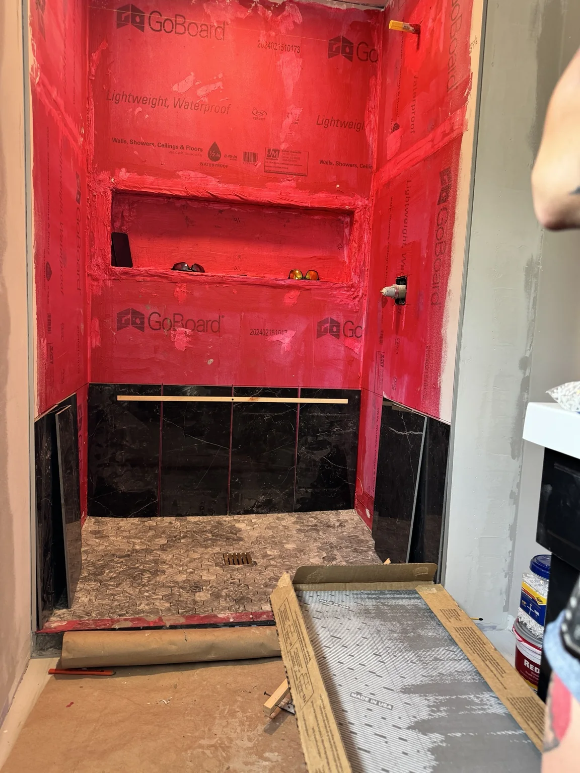 Shower waterproofing and tile installation in progress